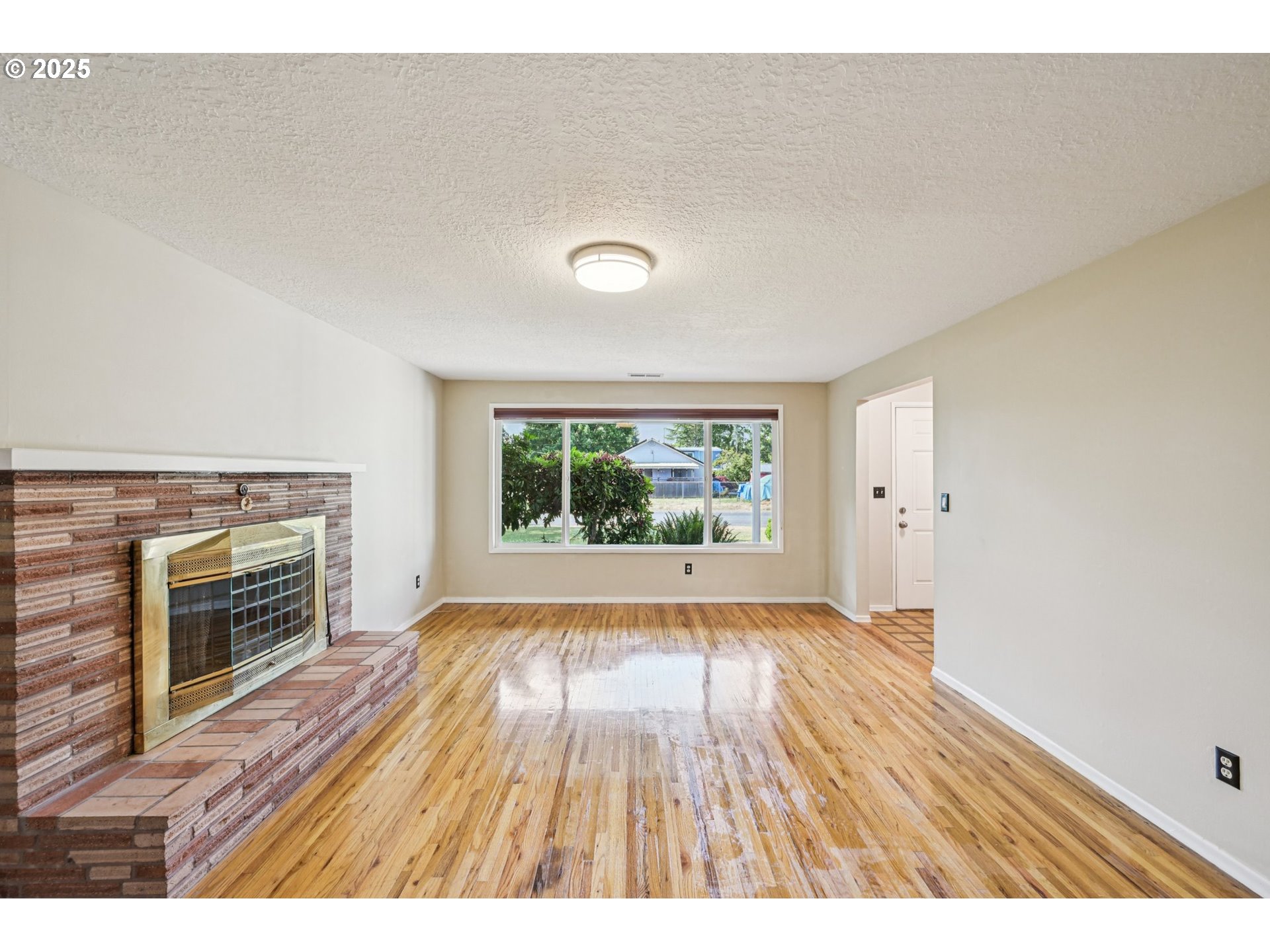 1631 North Clark Street Cornelius, OR 97113 - Photo 4 of 29 a view of empty room with wooden floor and fireplace