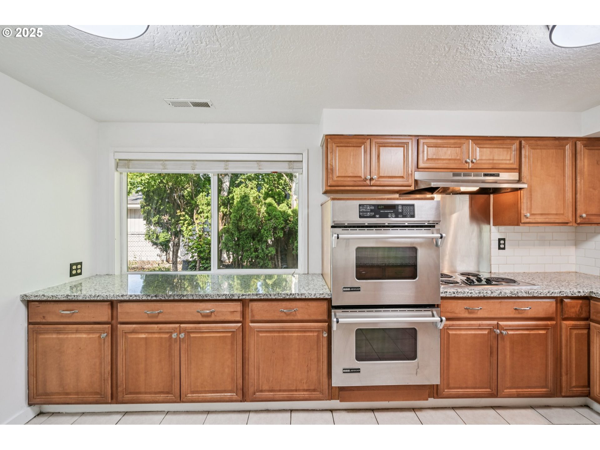 1631 North Clark Street Cornelius, OR 97113 - Photo 8 of 29 a kitchen with granite countertop a stove a microwave and wooden cabinets