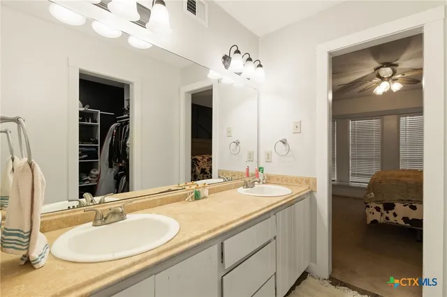 a en suite bathroom with double vanity and a mirror