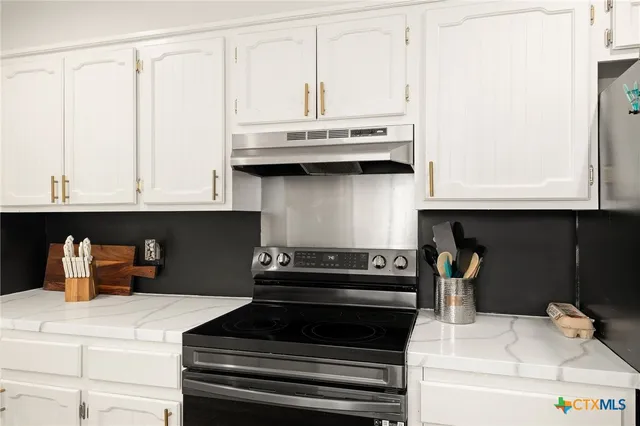 a kitchen with cabinets and stainless steel appliances