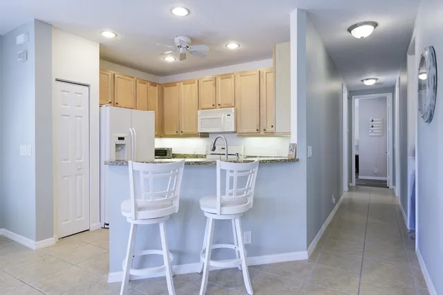a kitchen with stainless steel appliances granite countertop a refrigerator and a stove top oven