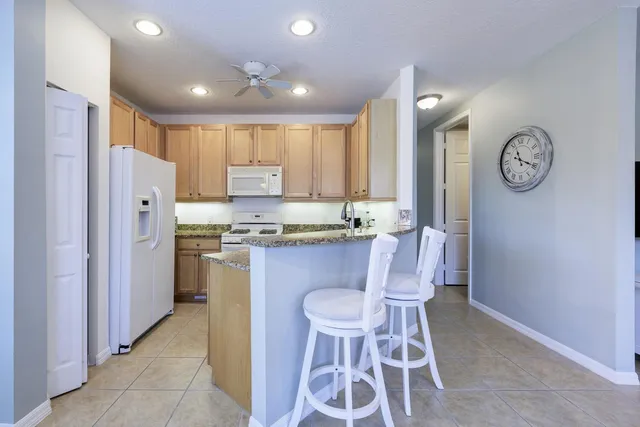 a kitchen with refrigerator cabinets and chair