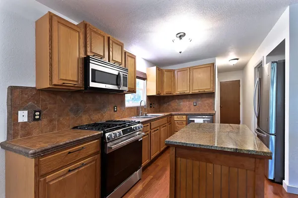 a kitchen with a sink a stove and cabinets