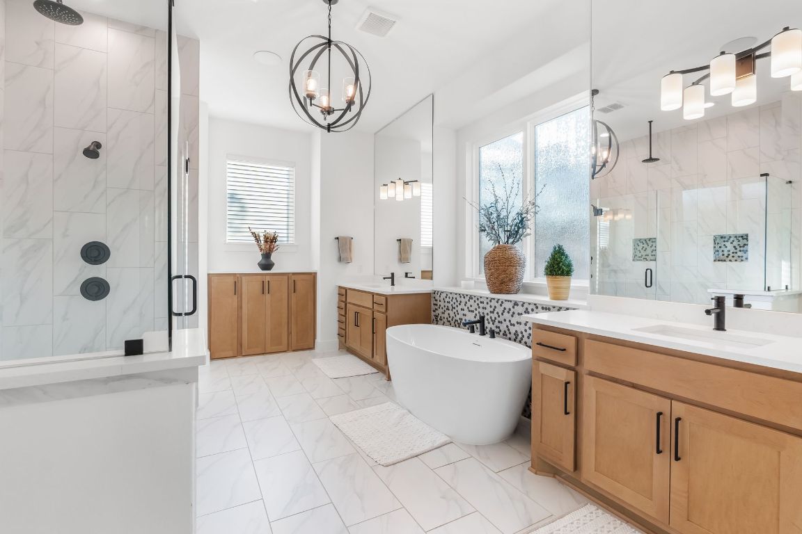 4612 Destination Way Jonestown, TX 78645 - Photo 20 of 37 a spacious bathroom with a double vanity sink a mirror and a bathtub