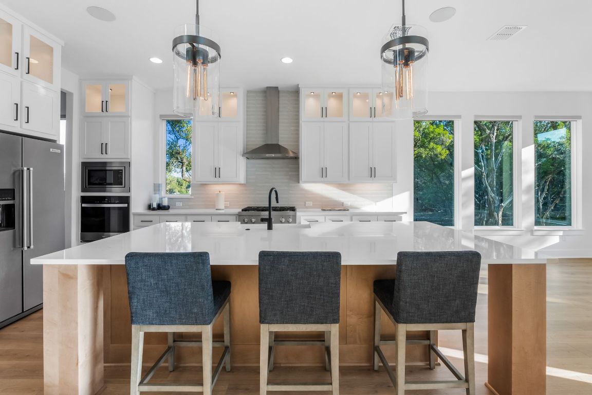 4612 Destination Way Jonestown, TX 78645 - Photo 5 of 37 a kitchen with stainless steel appliances granite countertop a table chairs and a kitchen view