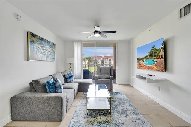 a living room with furniture ceiling fan and a window