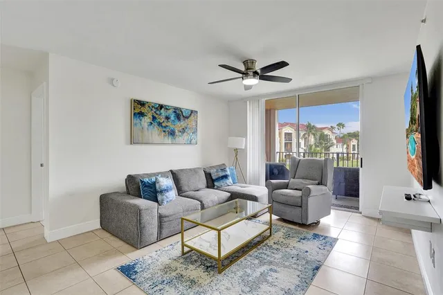 a living room with furniture a flat screen tv and a window