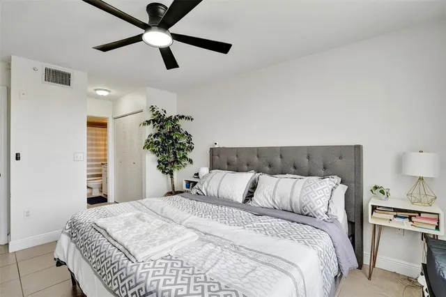 a bedroom with a bed and a potted plant