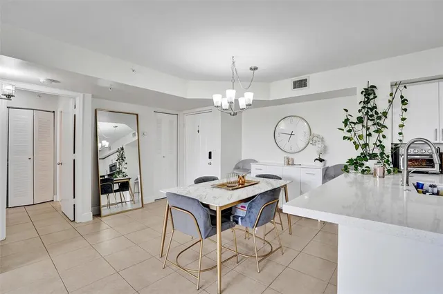 a living room with furniture a clock and a view of kitchen