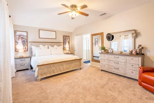 a spacious bedroom with a large bed and a chandelier