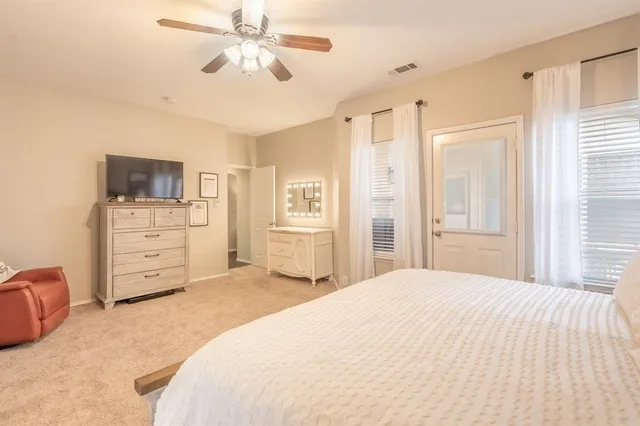 a bedroom with a bed a dresser and a chandelier