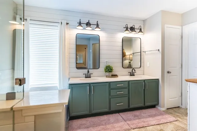 a bathroom with double vanity sink and a mirror