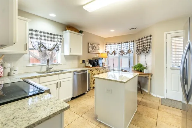 a kitchen with a sink a stove a refrigerator and black cabinets