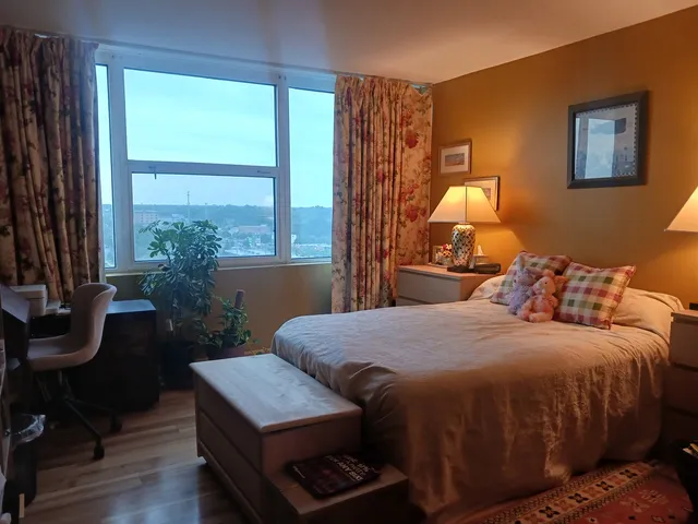 a bedroom with a bed chairs and a window