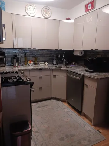 a kitchen with stainless steel appliances granite countertop a stove a sink and a microwave