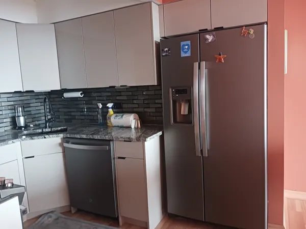 a kitchen with metallic refrigerator and sink
