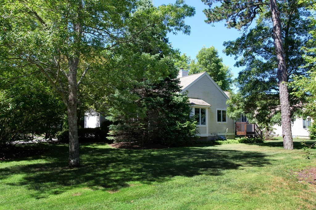 56 Pine Hill Boulevard, Unit 72 Mashpee, MA 02649 - Photo 5 of 12 a front view of a house with a yard and trees