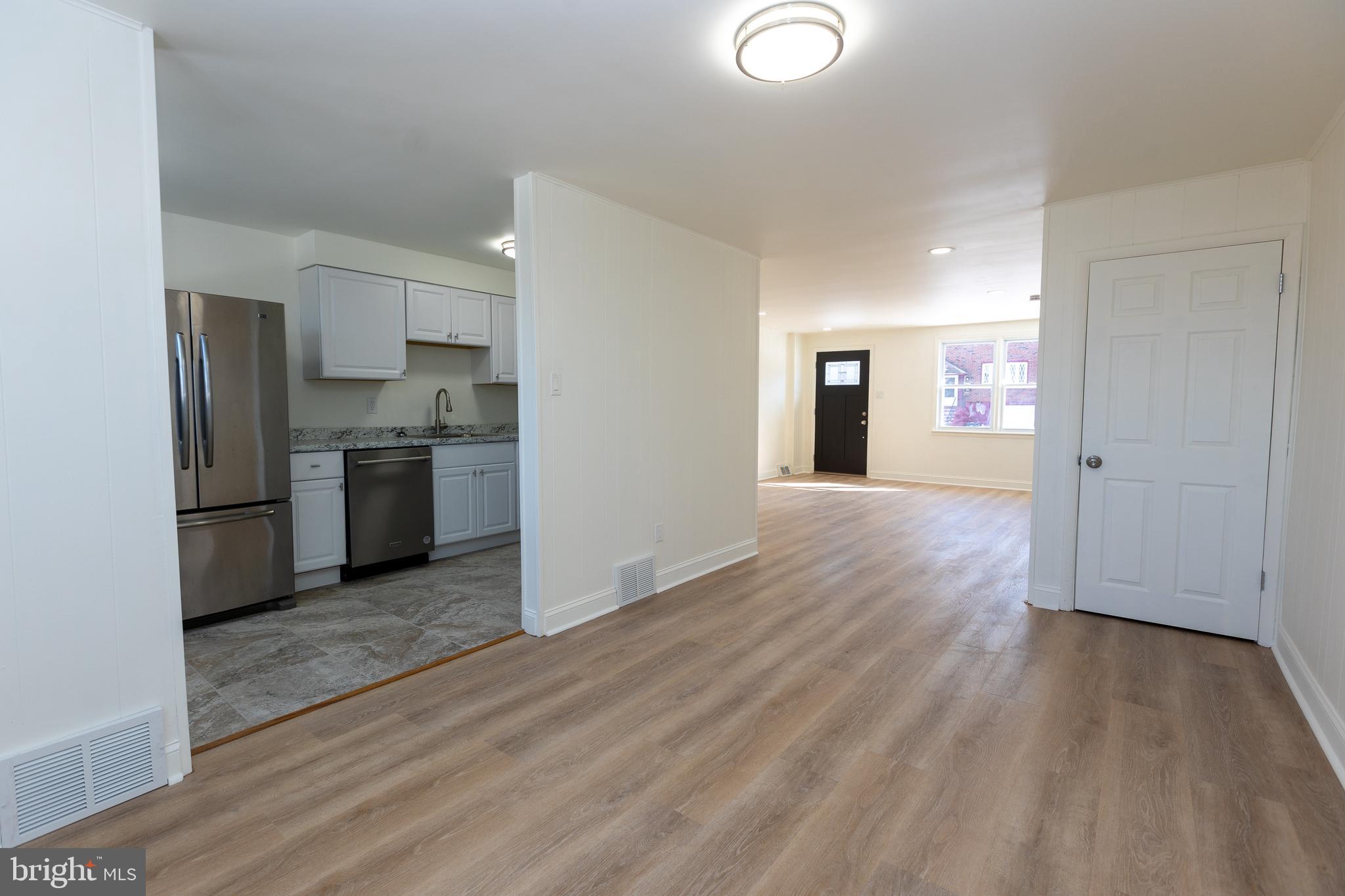 a view of a kitchen with wooden floor electronic appliances and window