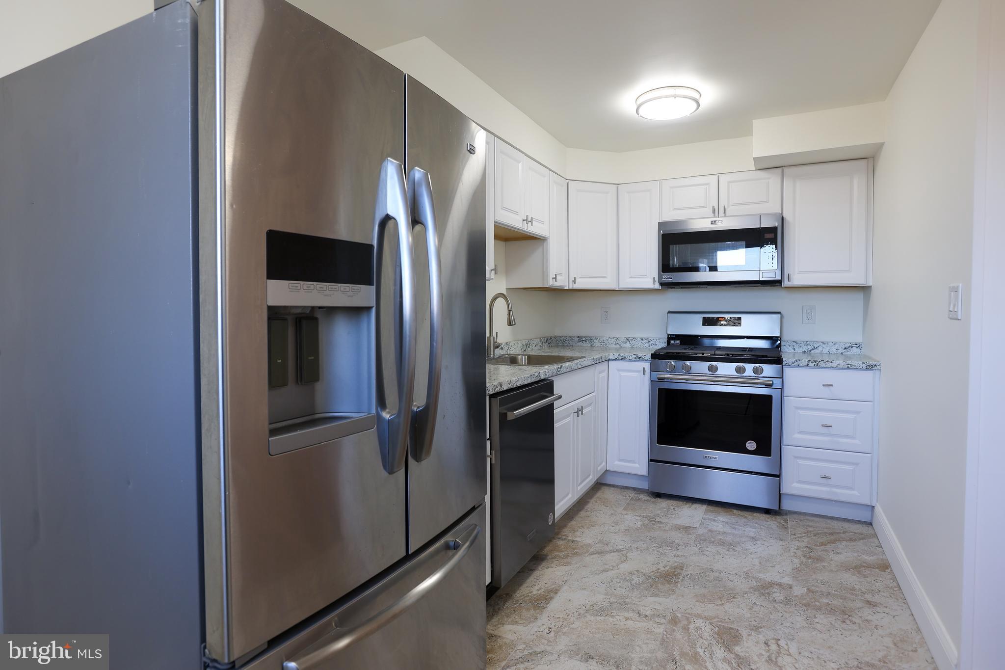 1218 Harshaw Road Brookhaven, PA 19015 - Photo 7 of 21 a kitchen with stainless steel appliances a refrigerator stove and microwave