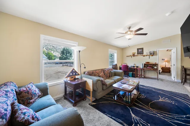 a living room with furniture a flat screen tv and kitchen view