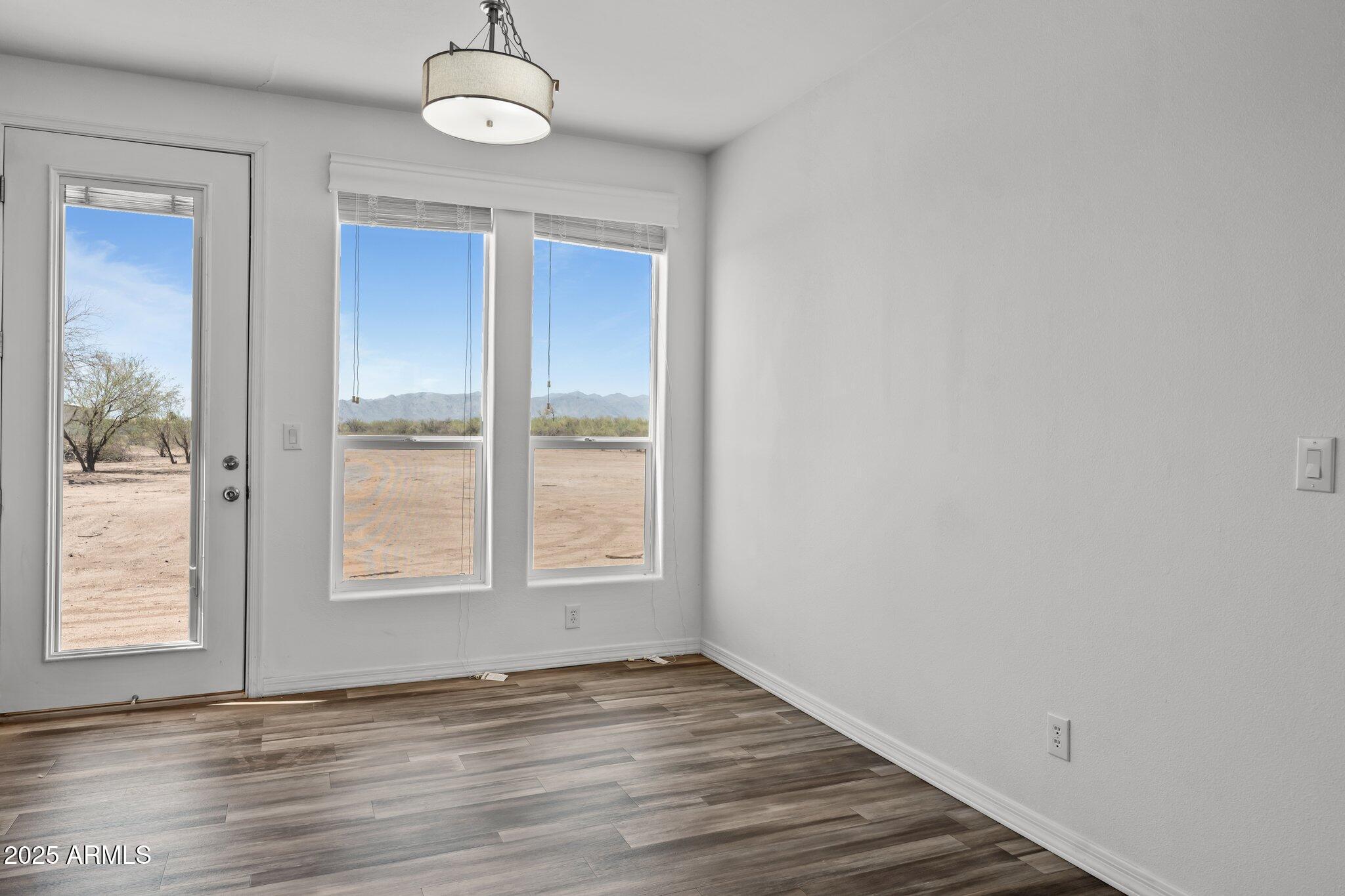 20909 West Bradley Road Wittmann, AZ 85361 - Photo 18 of 37 an empty room with wooden floor and windows