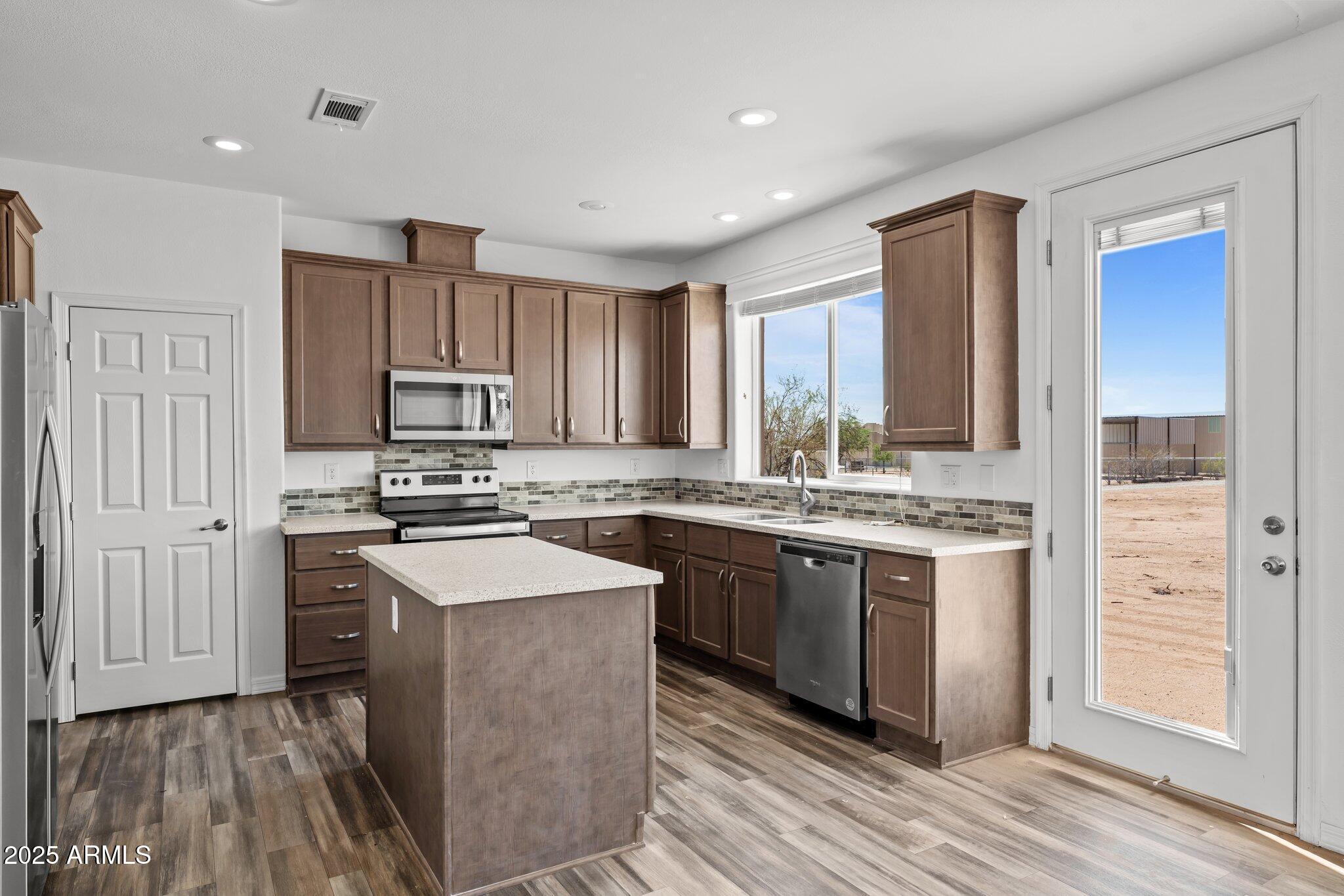 20909 West Bradley Road Wittmann, AZ 85361 - Photo 2 of 37 a kitchen with stainless steel appliances granite countertop a stove a sink dishwasher and a refrigerator with wooden floor
