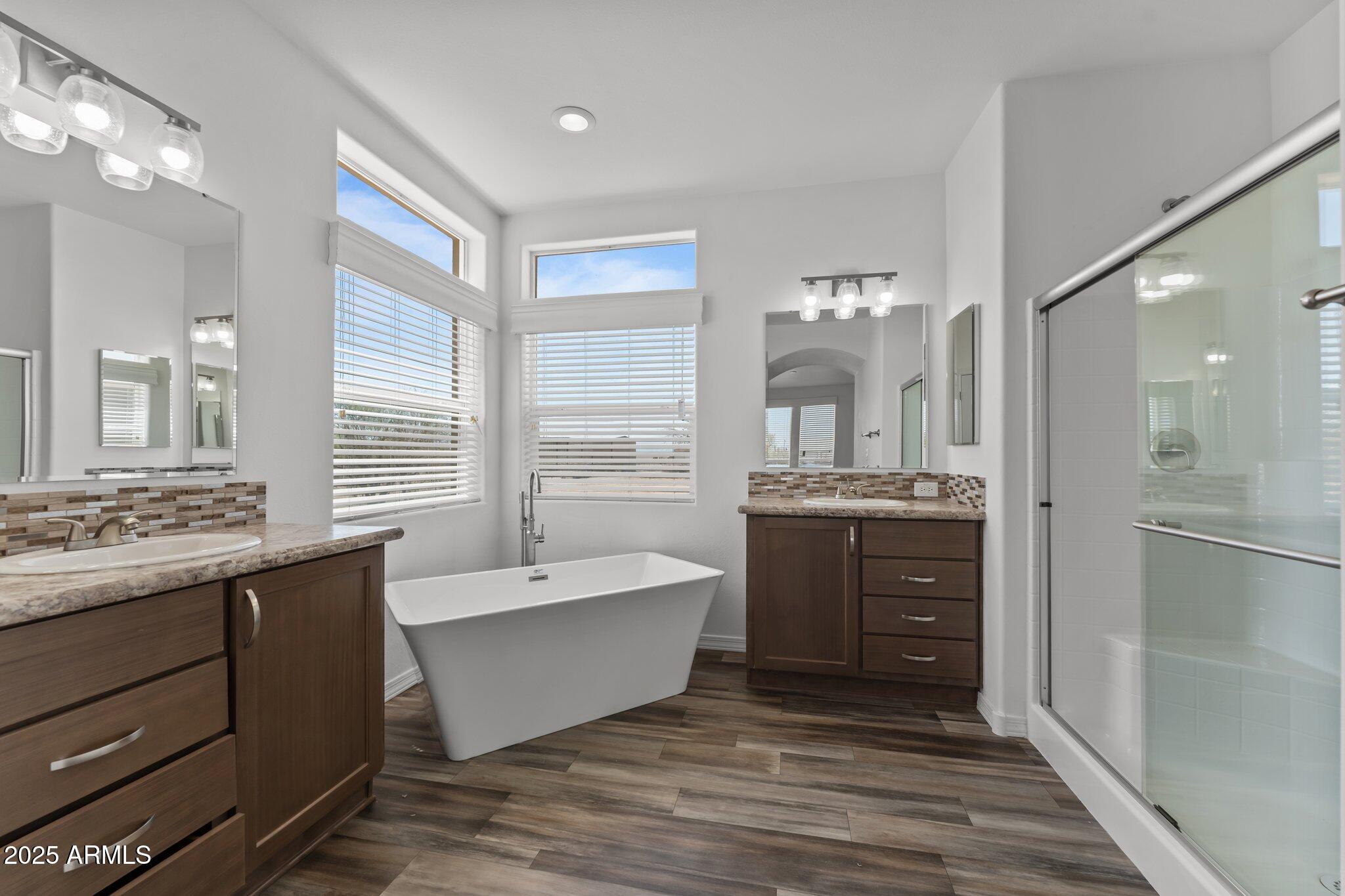 20909 West Bradley Road Wittmann, AZ 85361 - Photo 4 of 37 a spacious bathroom with a double vanity sink a mirror and a bathtub