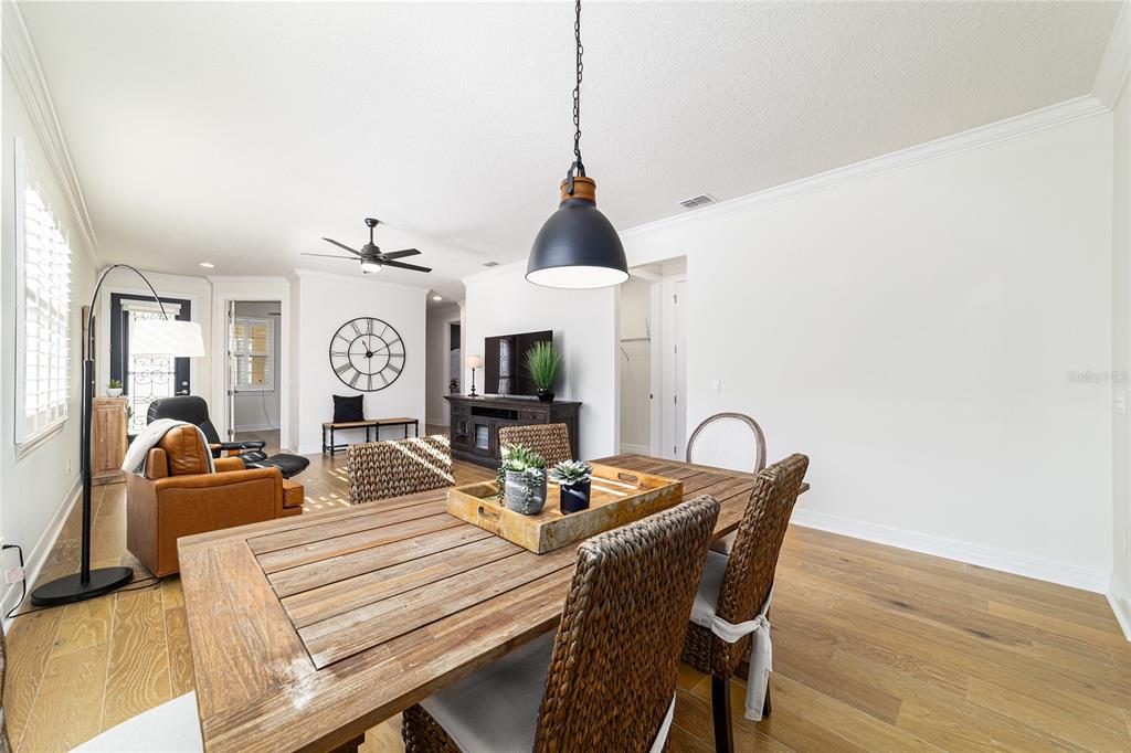 9710 Southwest 76th Lane Road Ocala, FL 34481 - Photo 13 of 45 a dining room with furniture a chandelier and wooden floor