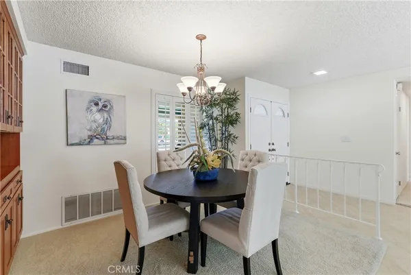 a view of a dining room with furniture and chandelier