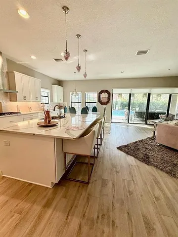 a kitchen with stainless steel appliances granite countertop a sink window and wooden floor
