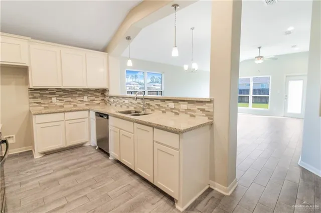 a kitchen with a stove a sink a refrigerator and wooden floor