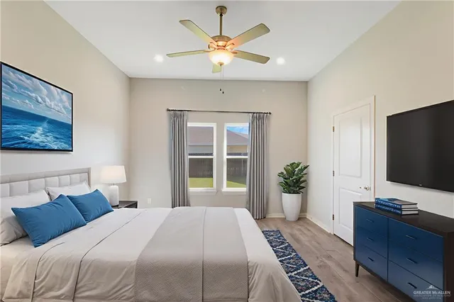 a bedroom with bed tv and a chandelier