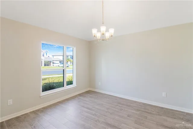 a view of a chandelier in big room and wooden floor