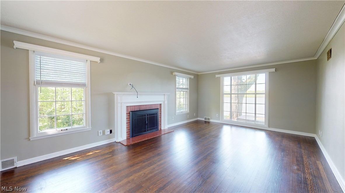 7421 Diagonal Road Kent, OH 44240 - Photo 11 of 48 Unfurnished living room with ornamental molding, a fireplace, floor to ceiling window provides a wealth of natural light, and dark wood-type flooring