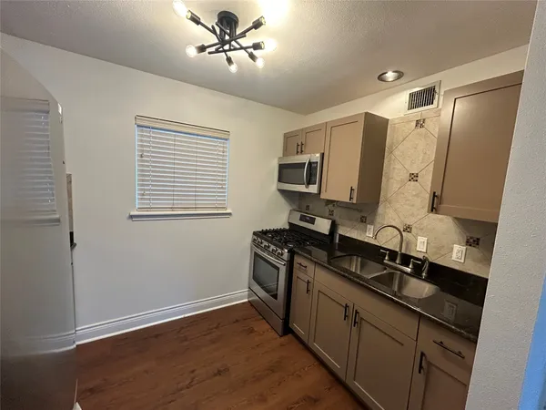 a kitchen with a sink appliances and cabinets