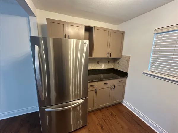 a kitchen with stainless steel appliances granite countertop a refrigerator and a sink