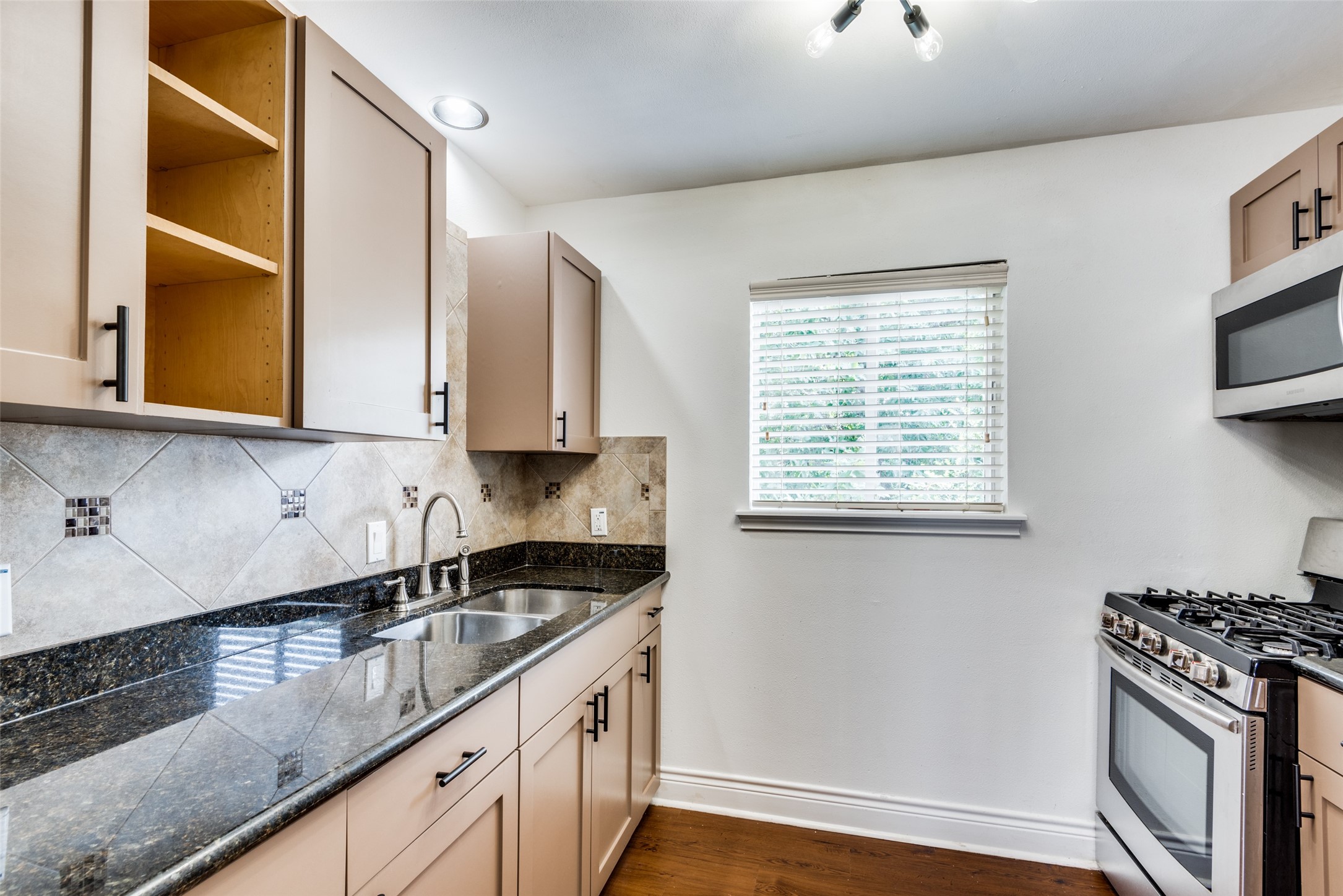 5612 Grover Avenue, Unit 101 Austin, TX 78756 - Photo 2 of 15 a kitchen with stainless steel appliances granite countertop a sink a stove and a wooden cabinets