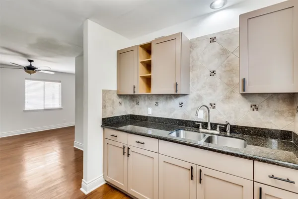 a kitchen with granite countertop white cabinets and a sink