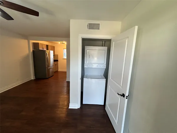 a view of a hallway with wooden floor and closet