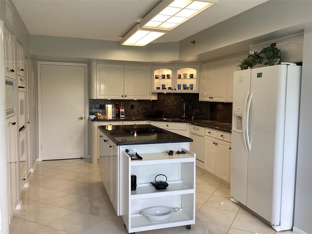 7567 Imperial Drive, Unit 201 Boca Raton, FL 33433 - Photo 11 of 41 a kitchen with cabinets and a stove top oven