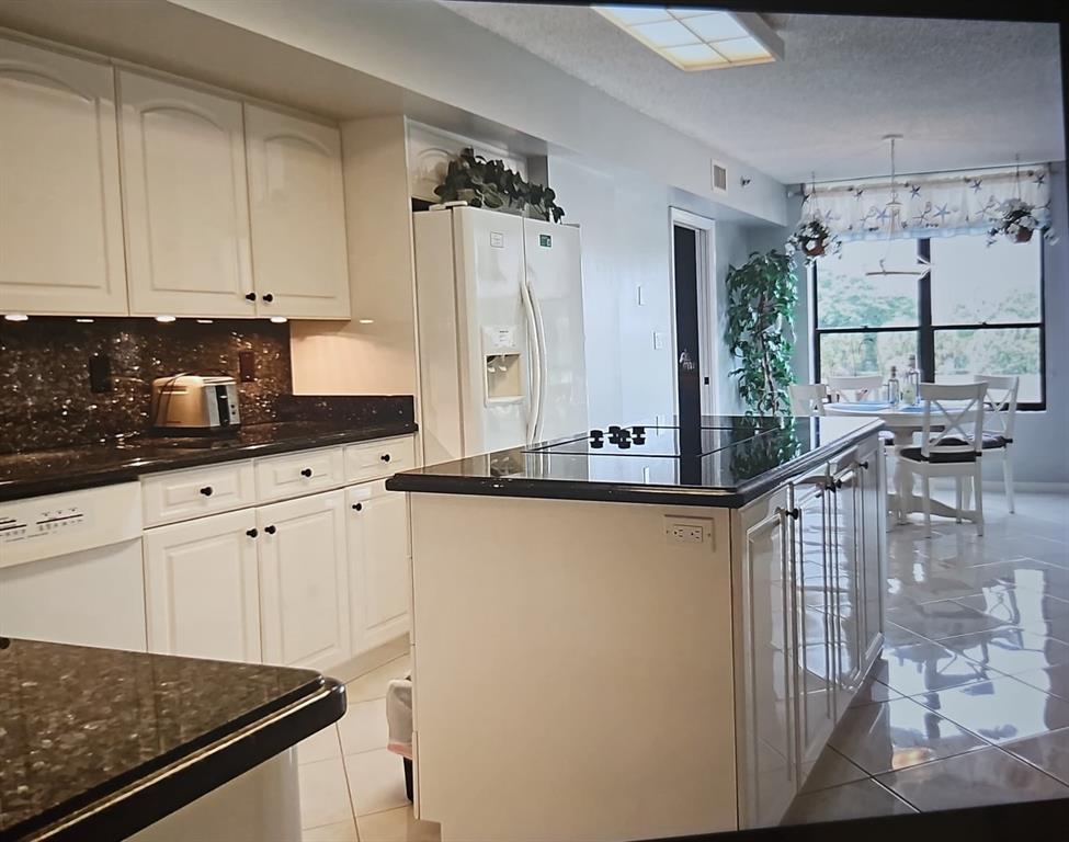 7567 Imperial Drive, Unit 201 Boca Raton, FL 33433 - Photo 13 of 41 a kitchen with stainless steel appliances granite countertop a stove a sink and a refrigerator