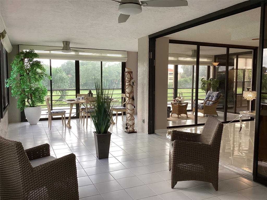 7567 Imperial Drive, Unit 201 Boca Raton, FL 33433 - Photo 17 of 41 a living room with furniture and floor to ceiling windows