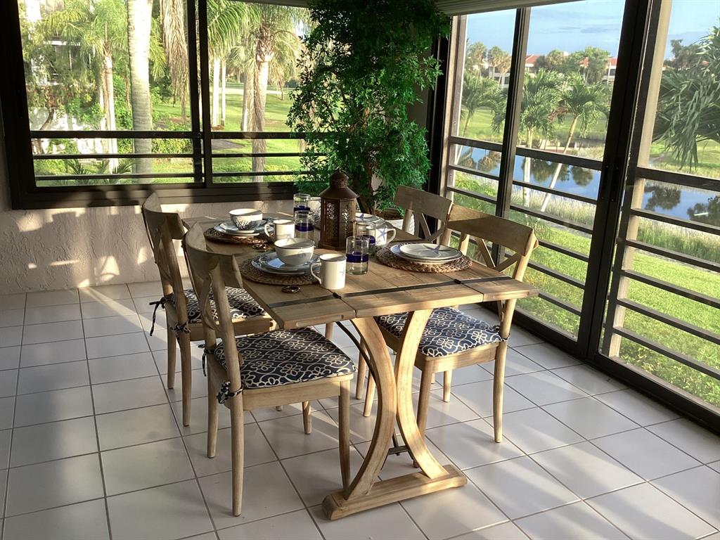 7567 Imperial Drive, Unit 201 Boca Raton, FL 33433 - Photo 19 of 41 a view of a dining room with furniture and floor to ceiling window