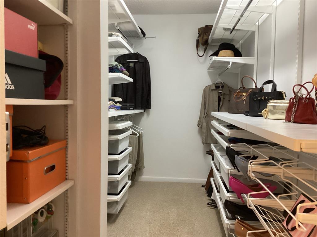 7567 Imperial Drive, Unit 201 Boca Raton, FL 33433 - Photo 25 of 41 a view of walk in closet with clothes and shoes
