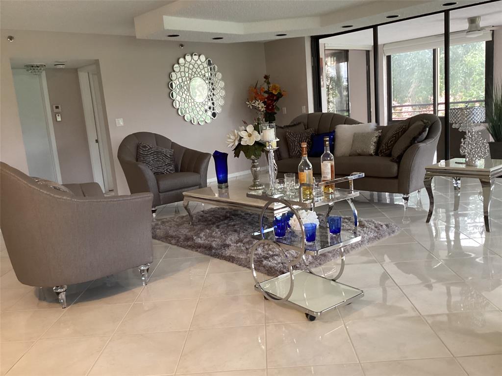 7567 Imperial Drive, Unit 201 Boca Raton, FL 33433 - Photo 6 of 41 a living room with furniture and floor to ceiling windows