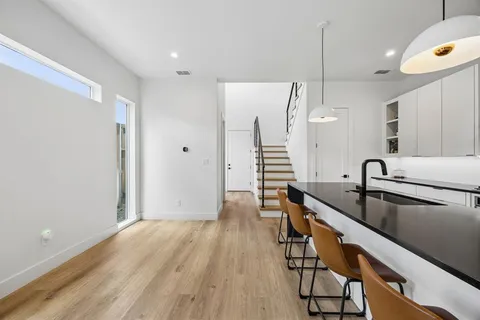 a kitchen with stainless steel appliances granite countertop a sink a stove and a wooden floors