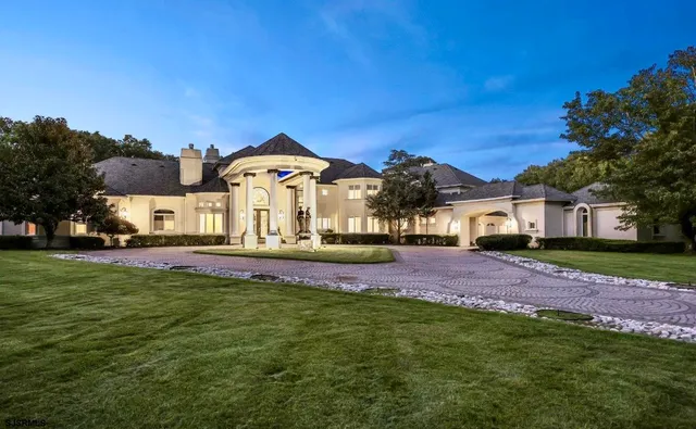a view of a house with a big yard and large trees