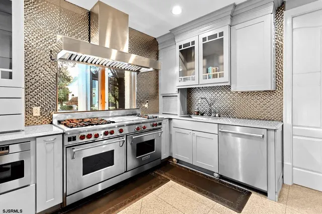 a kitchen with granite countertop cabinets stainless steel appliances and wooden floor