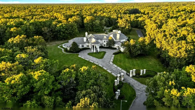 an aerial view of a houses with a yard and lake view