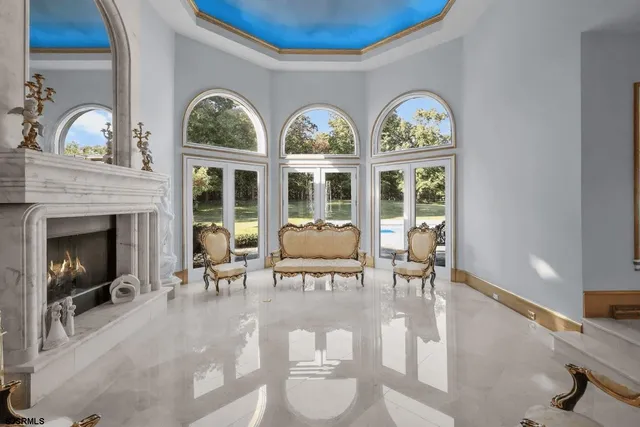 a living room with couches chairs and a fireplace with wooden floor